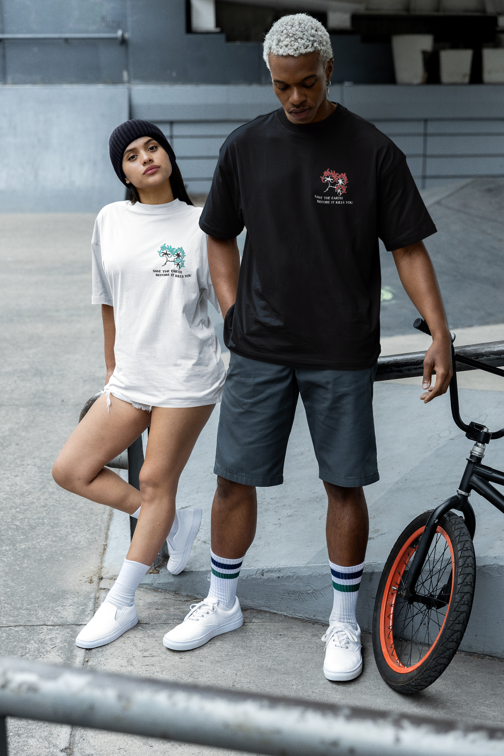 Two people standing next to a bicycle on a concrete surface. graphic streetwear tees