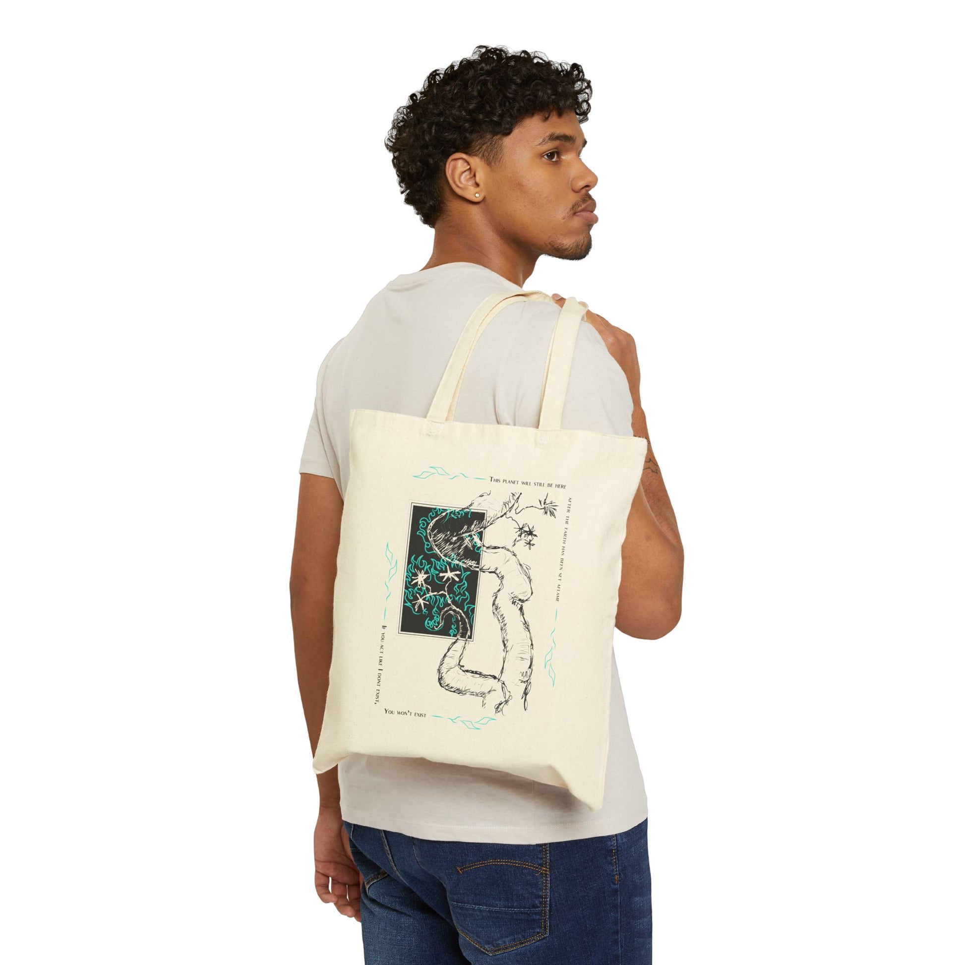 A person carrying a beige canvas cotton tote bag with a white and blue graphic design on the front.
